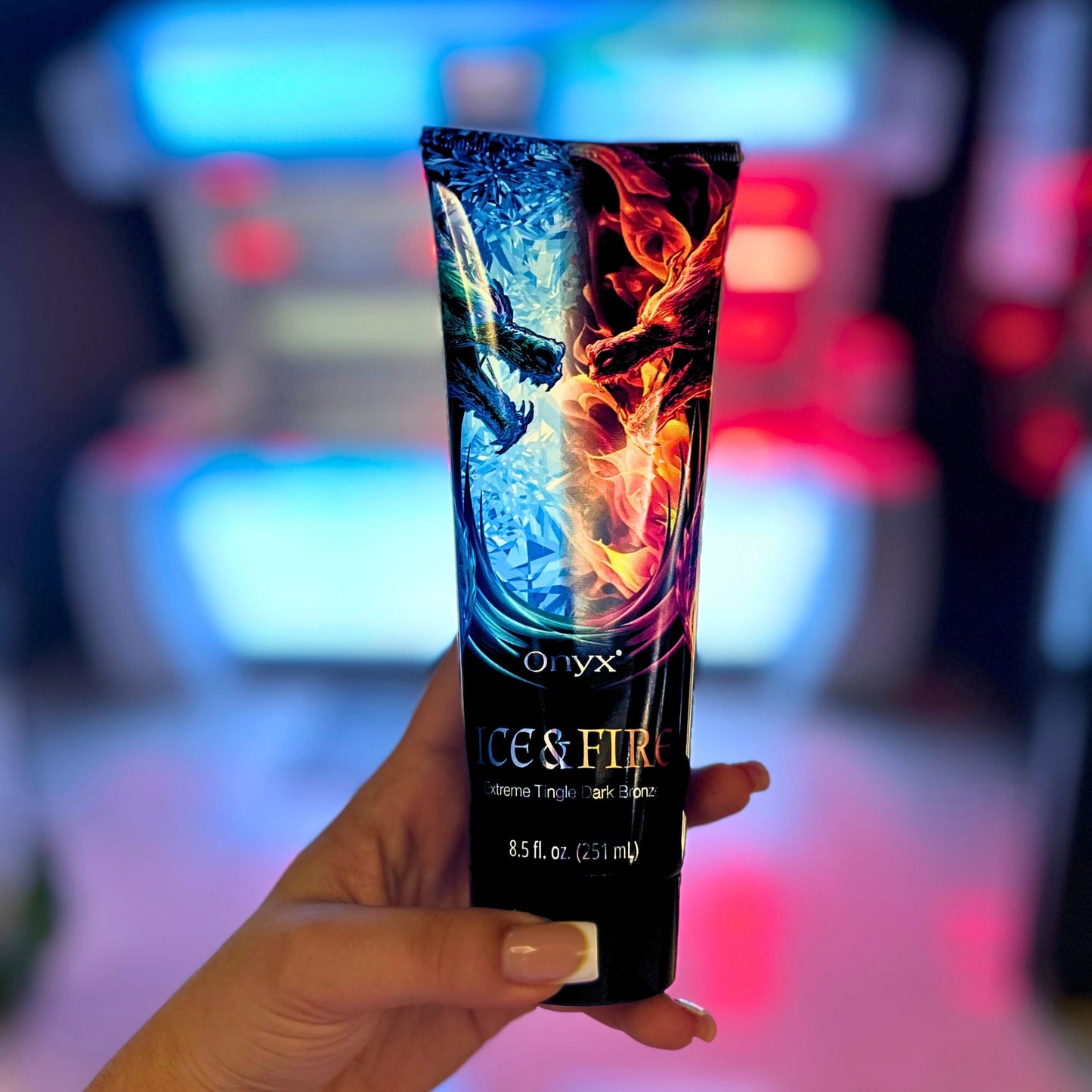 Onyx Ice & Fire Bräunungslotion in der Hand vor Solariumkulisse