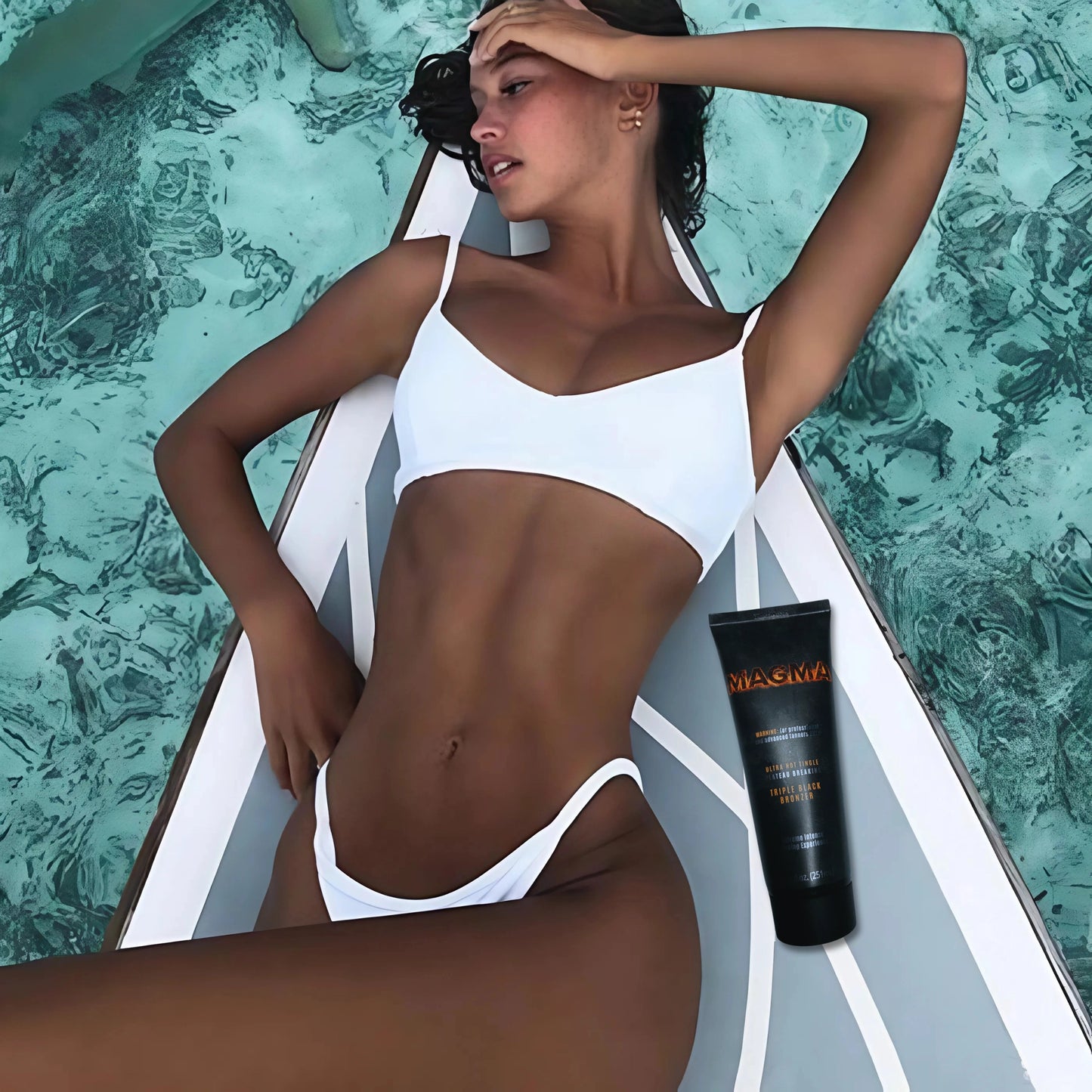 Frau mit weißem Bikini liegt auf einem Paddleboard über türkisfarbenem Wasser, Onyx Magma Lotion neben ihr positioniert – perfekte Bräune im Sommerurlaub
