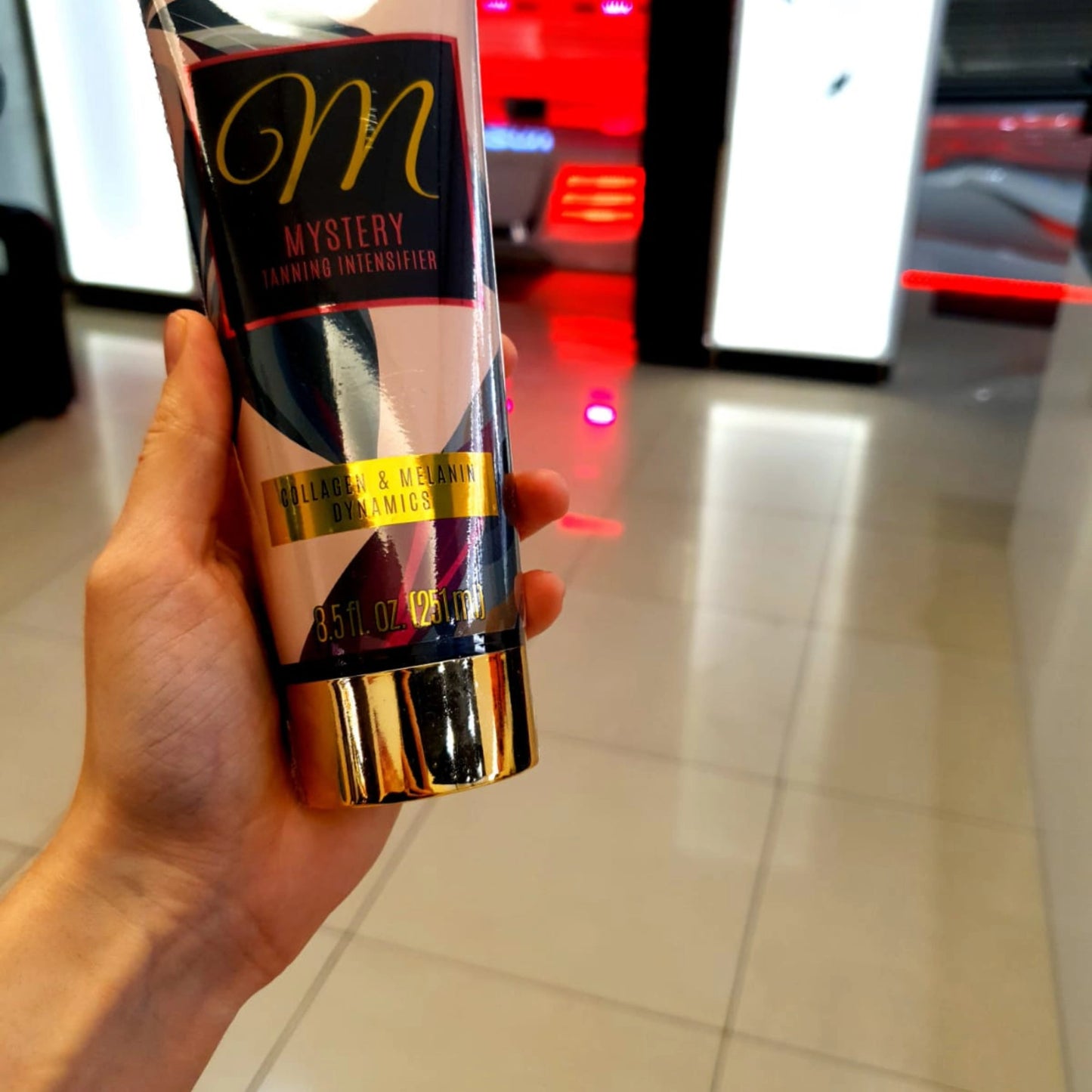 Onyx Mystery Bräunungslotion auf den Beinen einer Frau mit Fokus auf das elegante Verpackungsdesign