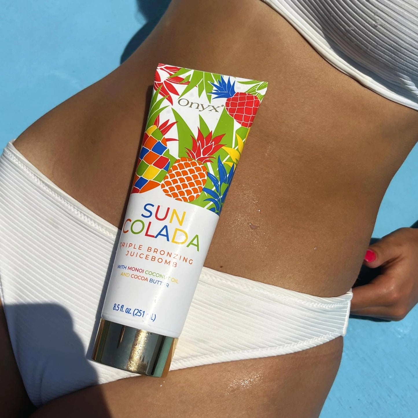 Suncolada Bräunungslotion auf gebräuntem Bauch mit blauem Hintergrund