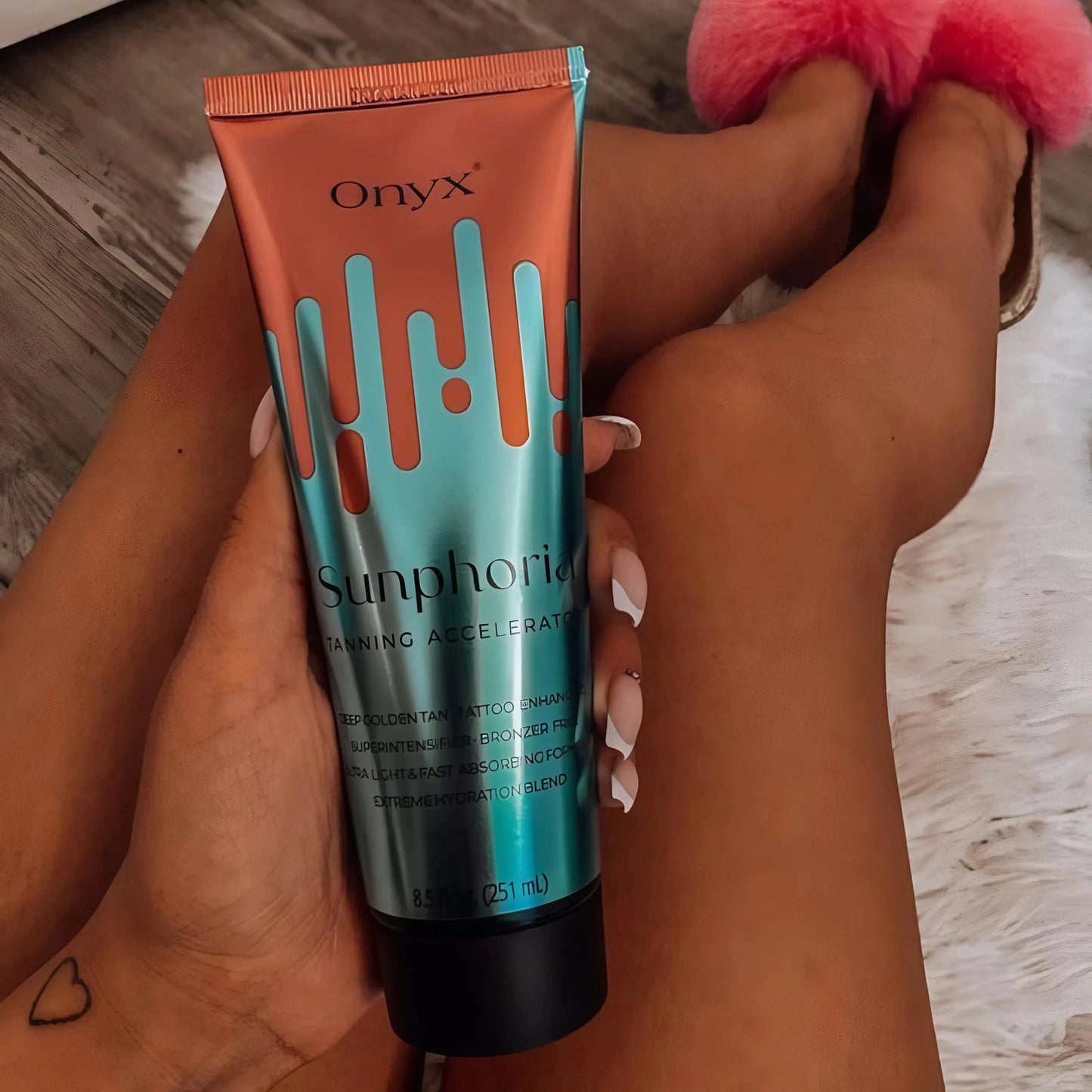 Nahaufnahme von Onyx Sunphoria Lotion auf gebräunten Beinen mit weißem Fell
