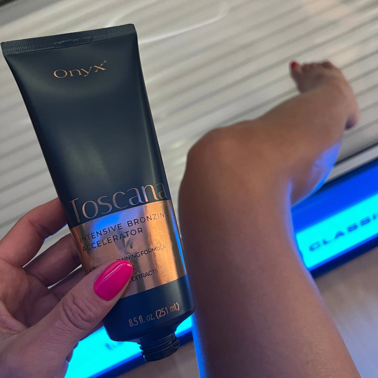 Geöffnete Onyx Toscana Tube vor Bein im Solarium mit pink lackierten Nägeln