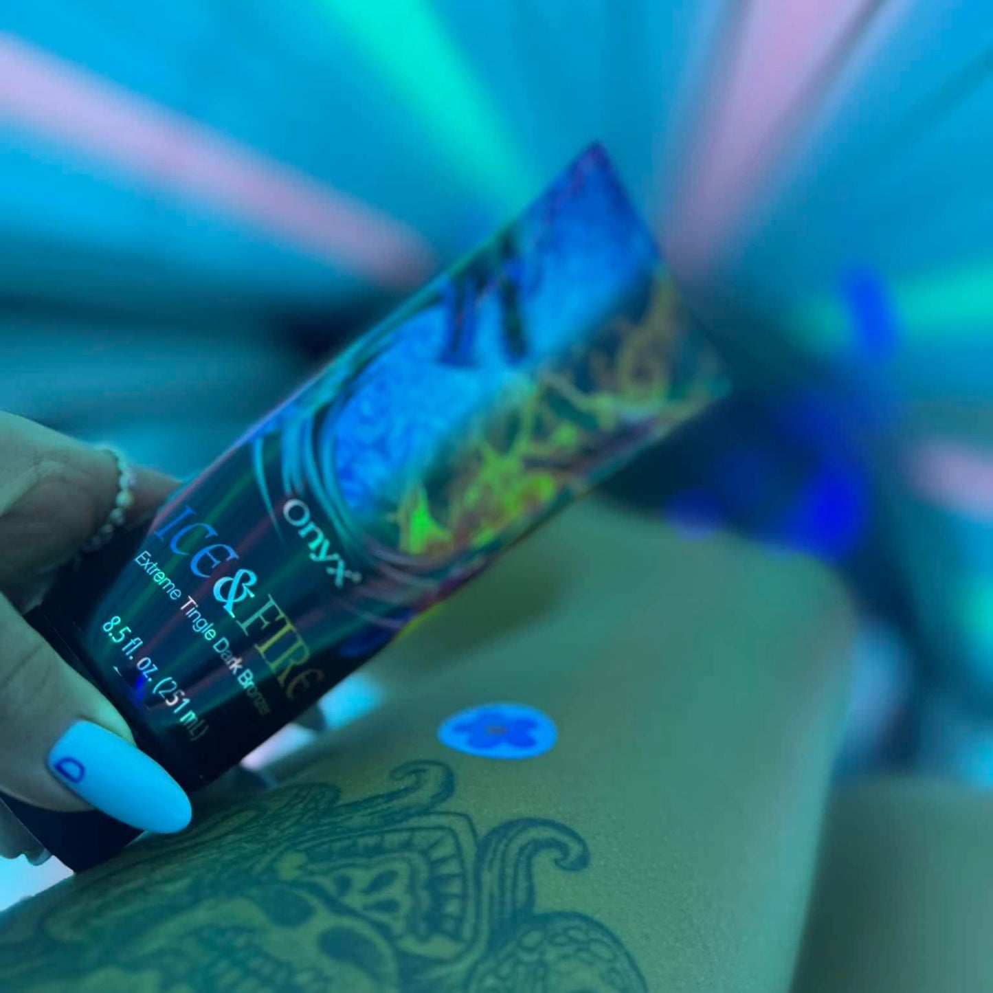 Ice & Fire Bräunungslotion auf Bein mit Tattoo während Solariumsitzung
