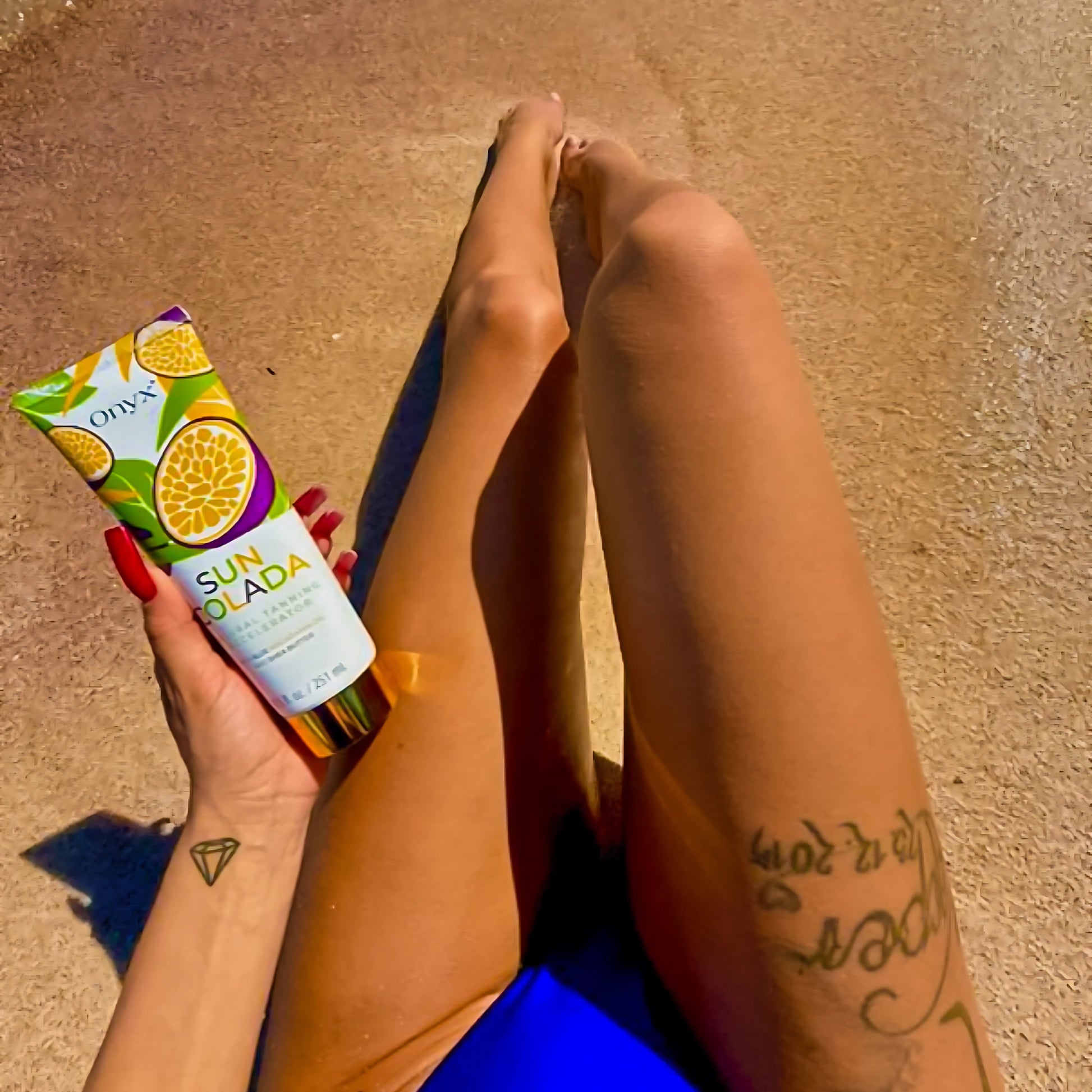 Close-up of woman holding Onyx Suncolada tanning lotion during sunbathing, designed for safe UV bed and sun tanning with natural ingredients and no bronzer